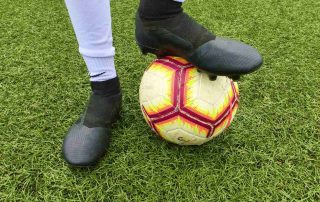 A player stands with foot poised on a football.